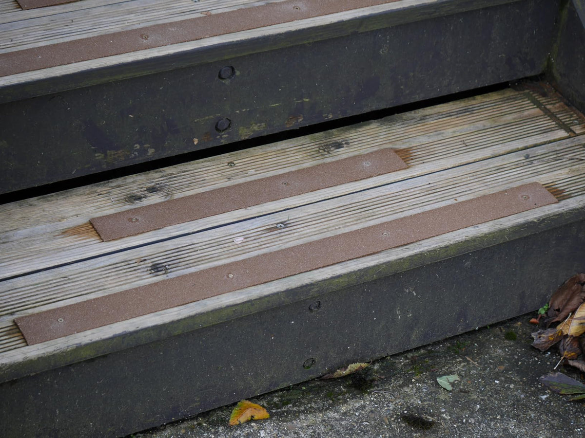 Brown anti-slip strips screwed onto outdoor wooden steps