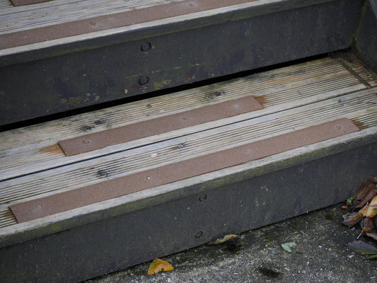 Brown anti-slip strips screwed onto outdoor wooden steps