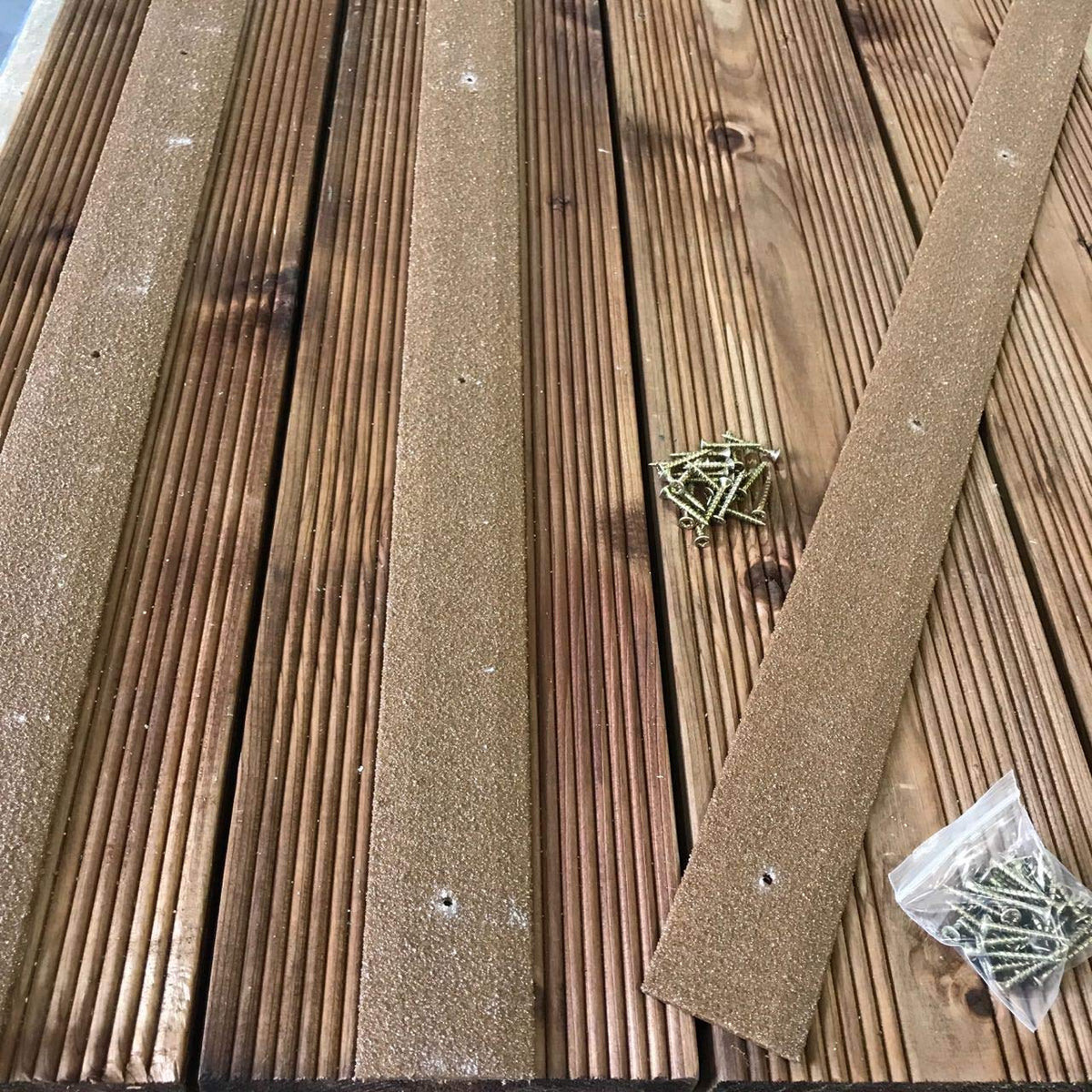 Brown anti-slip strips screwed onto outdoor wooden steps